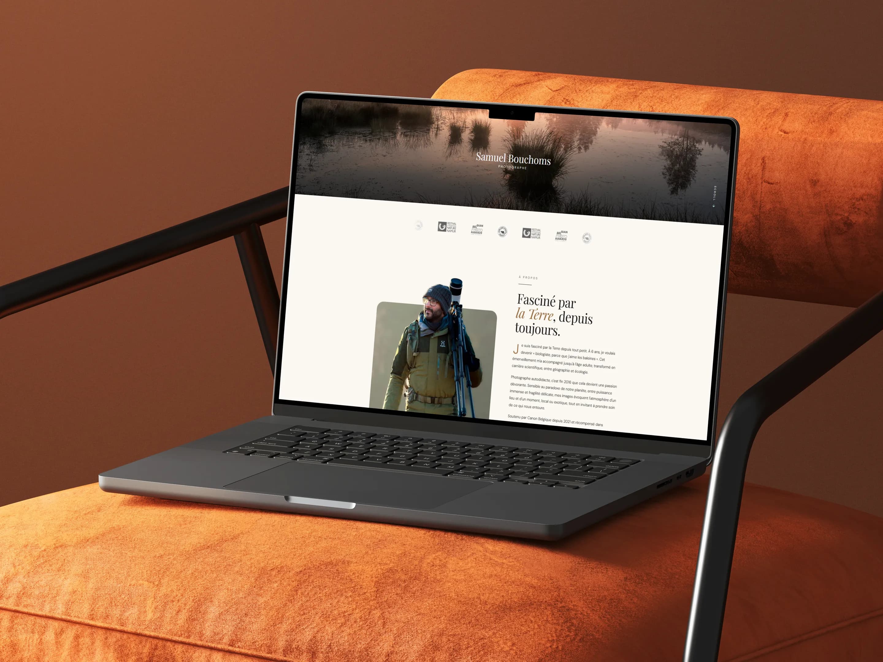 Site portfolio de Samuel Bouchoms ouvert sur un ordinateur portable posé sur un fauteuil orange