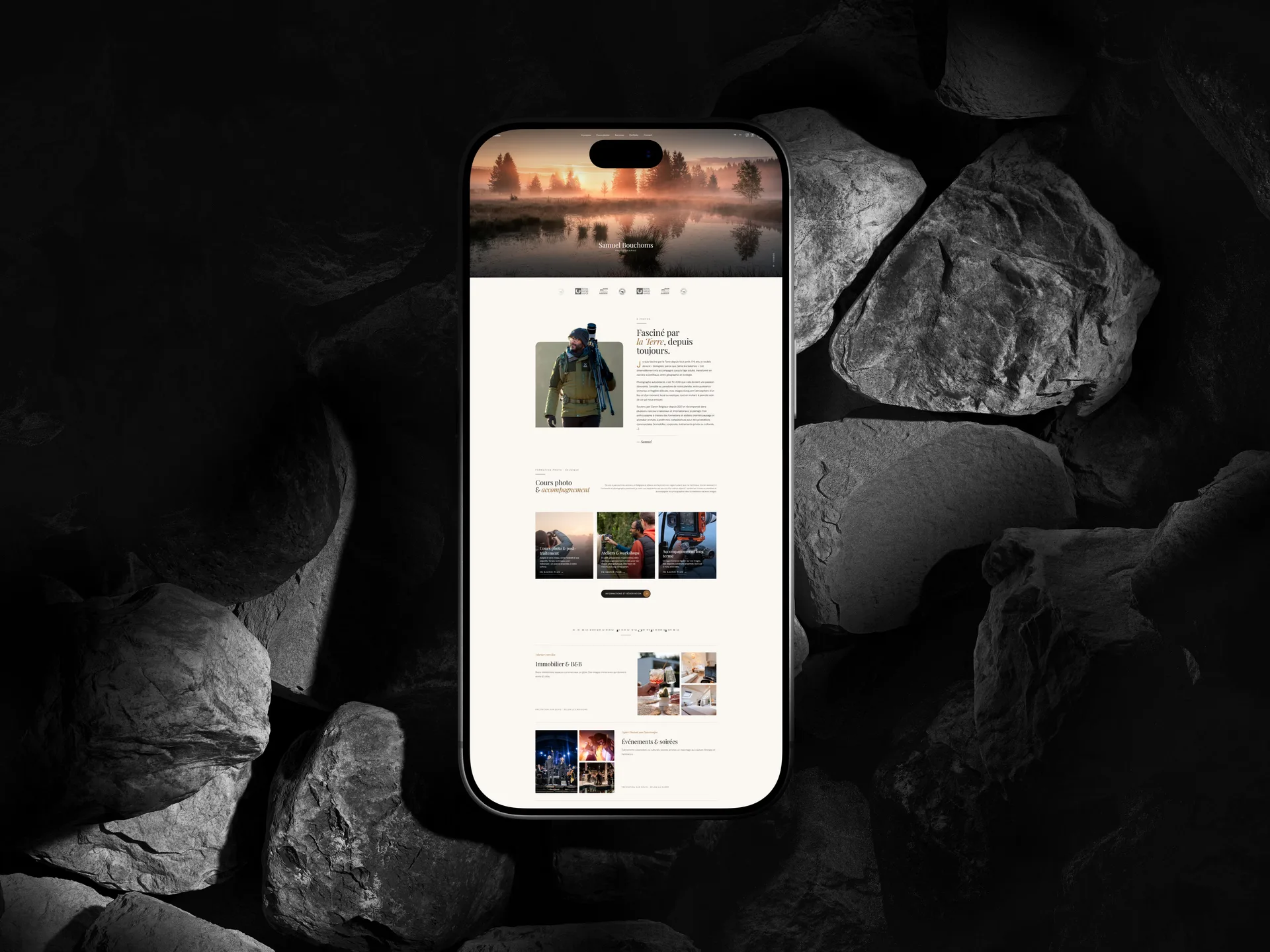 Site de Samuel Bouchoms affiché sur un iPhone posé sur des galets sombres